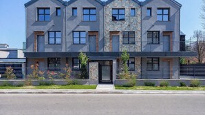 A modern multi-story building with a symmetrical facade, large windows, and a central entrance. - Flower Residence - Appartamento Lavanda (Lissone)