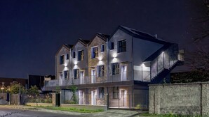 A multi-story residential building with balconies, a gated entrance, and a well-lit facade. - Flower Residence - Appartamento Lavanda (Lissone)