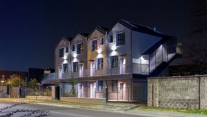 A modern multi-story building with balconies, a staircase, and a gated entrance. - Flower Residence - Appartamento Narciso (Lissone)