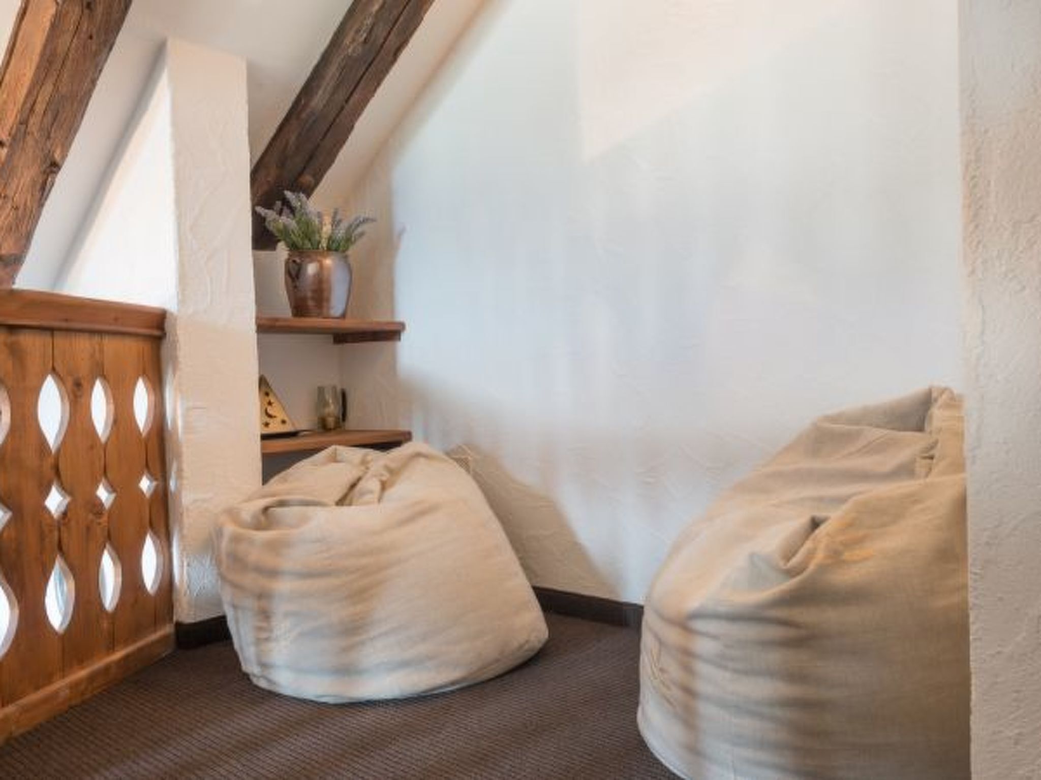 Ein Eckzimmer mit einer Holzhakenteilung, einem kleinen Regal mit einer Pflanze und zwei Sitzsäcken.