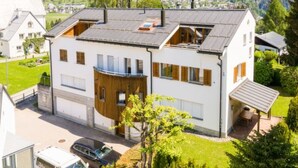 A modern two-story house with a garage, a balcony, and a view of a mountainous landscape. - Casa Alva - FLIMS by Interhome (Flims)