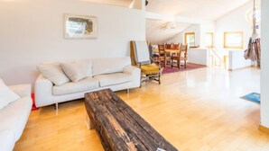 A spacious living area with a wooden bench, a white sofa, and a dining table with chairs. - Casa Alva - FLIMS by Interhome (Flims)
