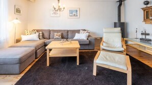 Una sala de estar con sofá, una mesa de centro, una silla, chimenea y decoración en la pared.