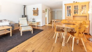 Una sala de estar acogedora con sofá, sillón y mesa de comedor de madera.