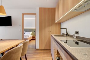 Une cuisine moderne dotée d’un îlot central, de meubles en bois et d’un téléviseur à écran plat.