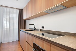 Une cuisine moderne avec des meubles en bois, un évier à deux bacs et une hotte intégrée.