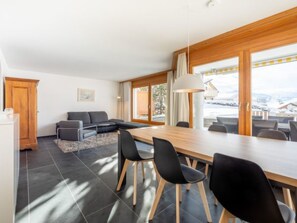 A modern interior with a dining area, a sofa, and a view of the outdoors. - Casa Guarda Val 1 by Interhome (Falera)