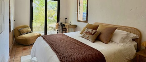 Une chambre à coucher avec un lit, une chaise, un bureau et une fenêtre.