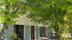 A building with multiple doors and windows, surrounded by trees and greenery. - Vacation home RALAYE by Interhome (Carces)