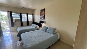 Una habitación de hotel con dos camas, una ventana con cortinas, un cuadro en la pared y suelo de baldosas.