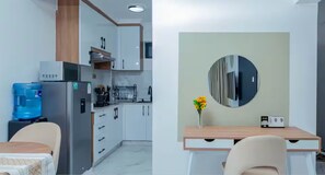 Eine moderne Küche mit weißen Schränken, einem Edelstahlkühlschrank und einem Wasserspender.