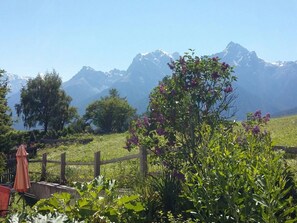 A mountainous landscape with a wooden fence, greenery, and a clear sky. - Chasa Stella, (Ftan) by Interhome (Ftan)