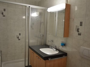 A bathroom with a glass shower enclosure, a white sink, and a mirror. - Villa Kuntner Bund, (Tschierv) by Interhome (Tschierv)