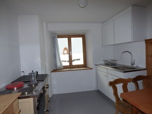 A compact kitchen with a window, a sink, and basic appliances. - Somvi 56, (Tschlin) by Interhome (Tschlin)