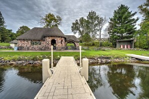 Ein Steingebäude mit Teich, Steg und Sitzgelegenheiten im Freien.