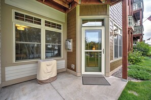 Ein Haus mit überdachter Veranda, einer Tür mit Fensterglas und einer kleinen Klimaanlage.