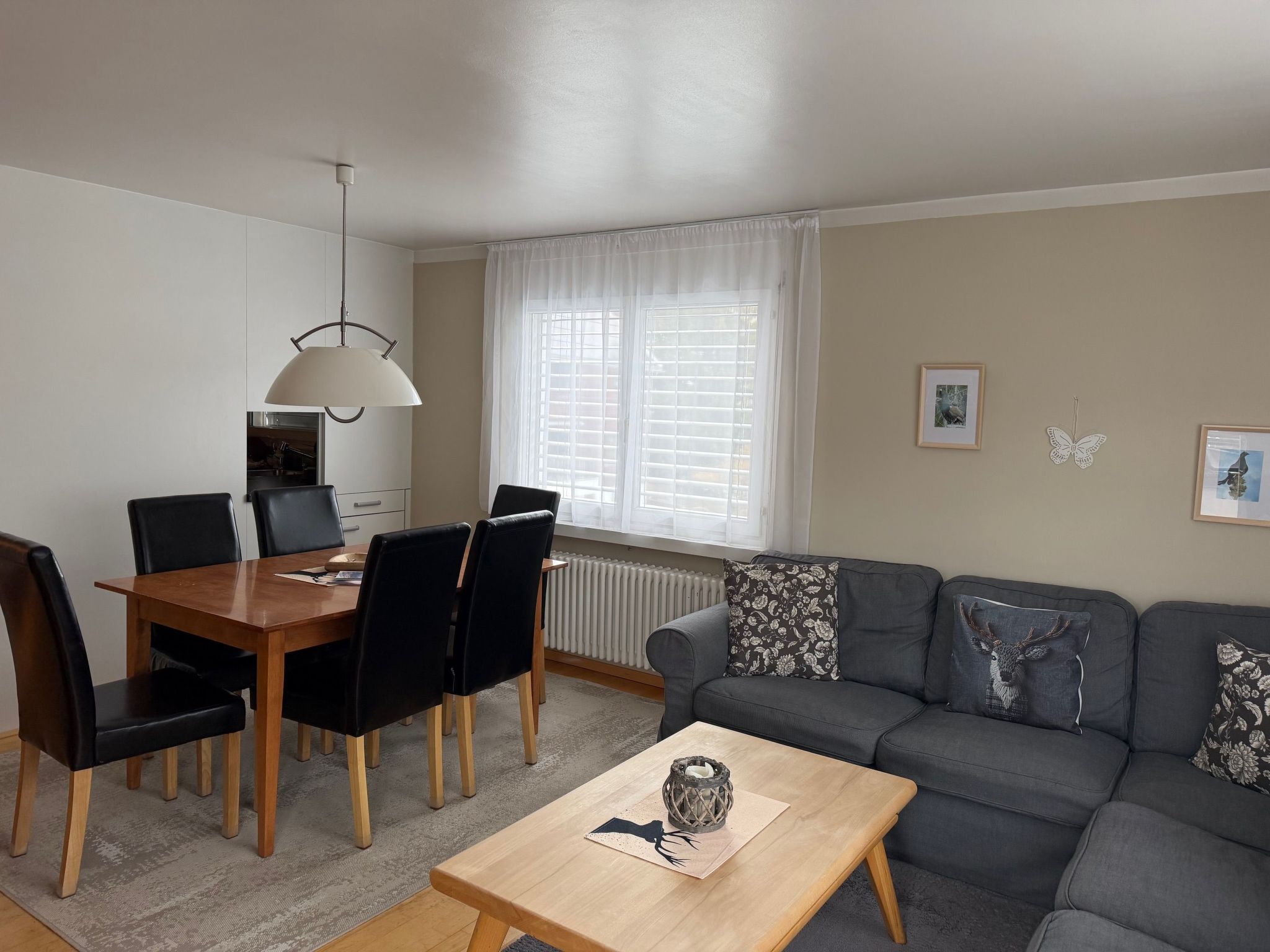 Een woonkamer met een eettafel, stoelen, een bank en een salontafel.