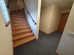 A wooden staircase with a handrail leading to a landing. - Ferienhaus Plaun Grond, (Tschierv) by Interhome (Tschierv)