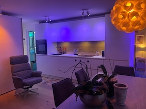 A modern kitchen with a dining area, featuring a purple-lit ambiance and contemporary design elements. - Chasa Uleiva, (Samnaun-Compatsch) by Interhome (Samnaun)