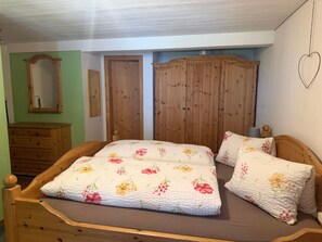 A bedroom with a wooden bed, a dresser, and a wardrobe. - Chasa Bazzi, (Scuol) by Interhome (Scuol)