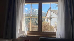 A room with a window, a chair, and a couch. - Chasa Bazzi, (Scuol) by Interhome (Scuol)
