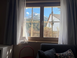A room with a window, a chair, and a couch. - Chasa Bazzi, (Scuol) by Interhome (Scuol)