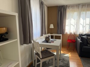 A compact living space with a dining table, a sofa, and a red chair. - Chasa Bazzi, (Scuol) by Interhome (Scuol)