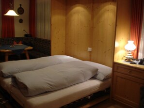 Ein Zimmer mit einem Bett, einem Tisch und einer Lampe.