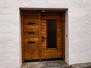 Uma porta de madeira com uma janela de tela metálica e uma placa acima.