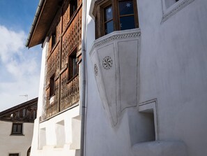 A building with wooden window frames and a white facade with decorative elements. - Archas 202A, (Sent) by Interhome (Sent)