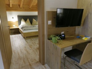 A room with a bed, a desk with a chair, a television, and a potted plant. - Chasa Madlaina, (Samnaun-Dorf) by Interhome (Samnaun)