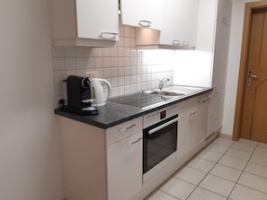 A compact kitchen with a coffee maker, kettle, and modern appliances. - Appartements Alpin Live, (Samnaun-Laret) by Interhome (Samnaun)