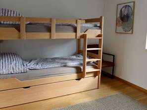 A bunk bed with a ladder, a single bed below, a chair, and a framed artwork on the wall. - Chasa Rachögna, (Scuol) by Interhome (Scuol)