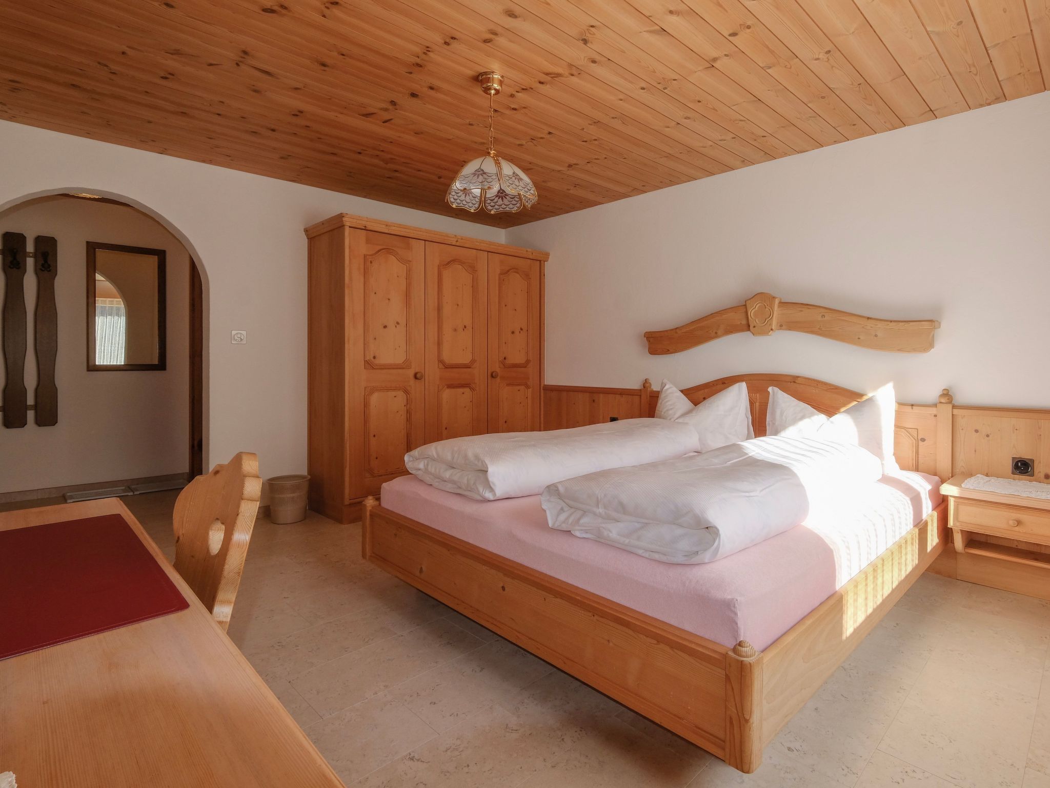 Una camera da letto in legno con un letto, un armadio e uno specchio.