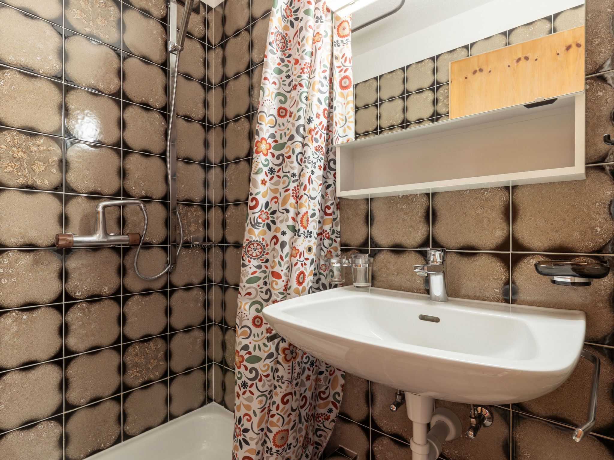Ein Badezimmer mit Dusche, Waschbecken und Spiegel.