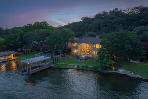 Une propriété au bord du lac, comprenant une grande maison, un quai et de nombreux espaces verts.
