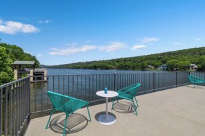 A terrace with a view of a lake, featuring a small table and two chairs. - 4BR Lake Austin Estate | Private Dock + Wake Surf Water | 200 Ft Frontage (Austin)
