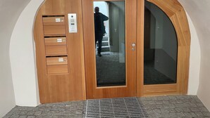 A wooden door with a glass panel, a keypad, and a small mailbox. - Stüvetta à Porta, (Scuol) by Interhome (Scuol)