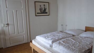 Ein Schlafzimmer mit einem Doppelbett, einer Tür und einem gerahmten Bild an der Wand.