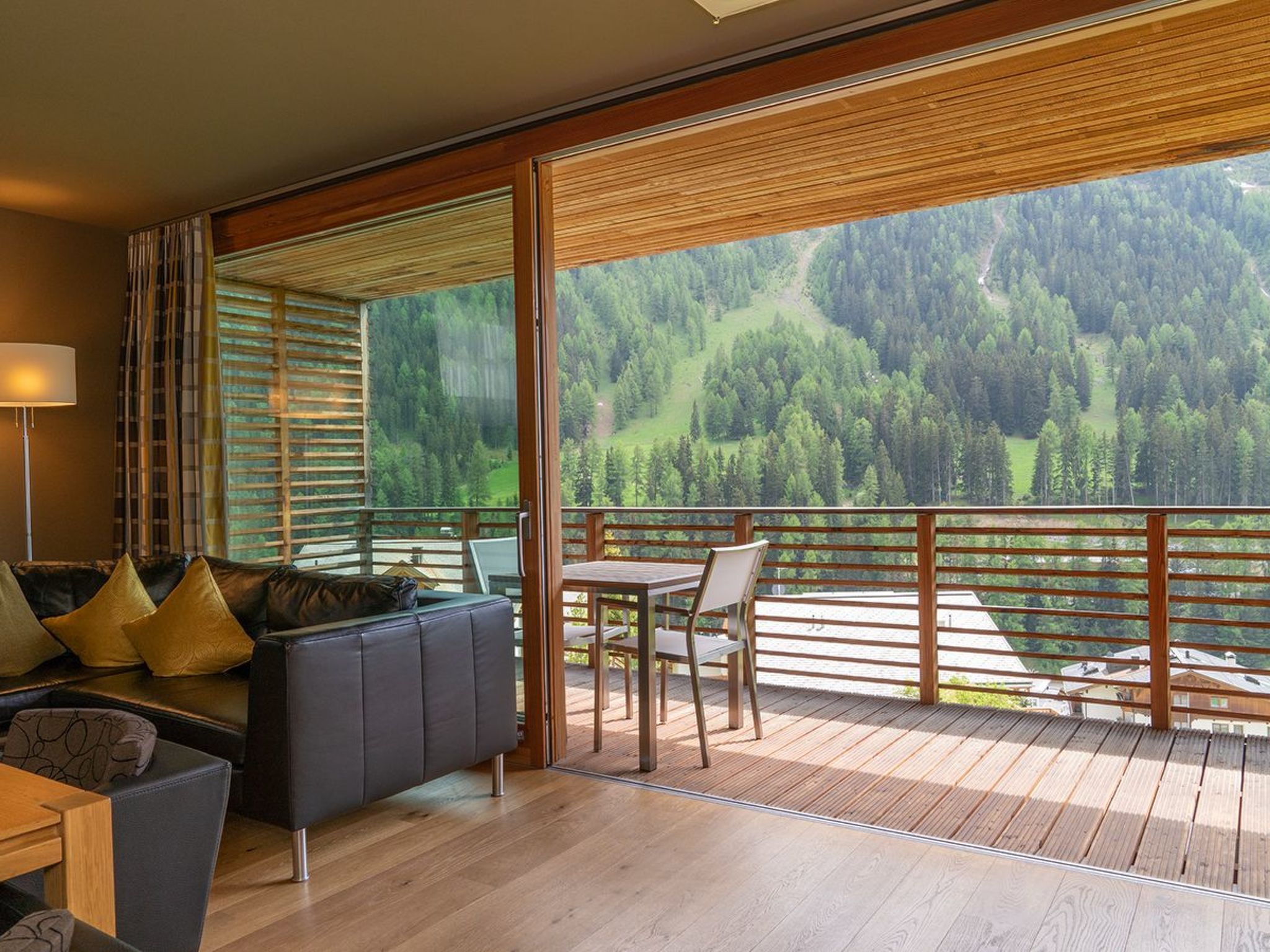 Et værelse med balkon og udsigt over en skovdal.