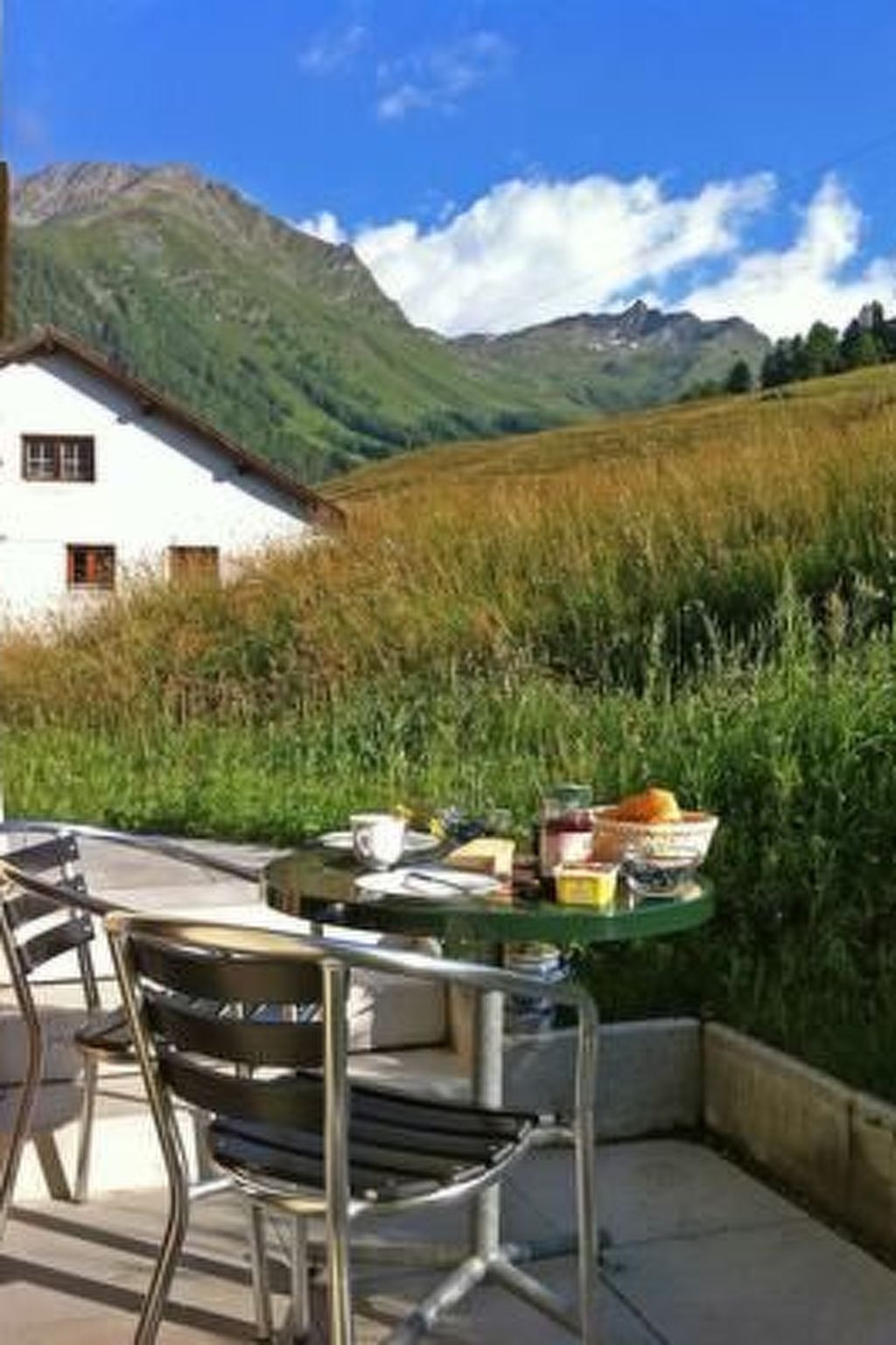 Ein Esstisch mit Stühlen und Blick auf einen Berg.