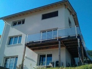 Un edificio de dos plantas con un balcón en el piso superior.