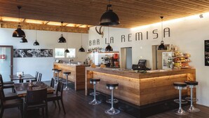 A bar with a wooden counter, bar stools, and a sign that reads 'BAR LA REMISA'. - Camping Muglin, (Müstair) by Interhome (Müstair)