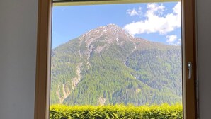 A bedroom with a window overlooking a mountain. - Leitner, (Ramosch) by Interhome (Ramosch)