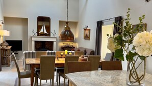 Een moderne woonkamer met een eethoek, een open haard en een grote spiegel.