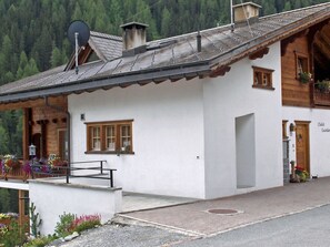 A chalet with a sloped roof, wooden balcony, and a small porch with flower boxes. - Chalet Guardaval, (Samnaun-Compatsch) by Interhome (Samnaun)