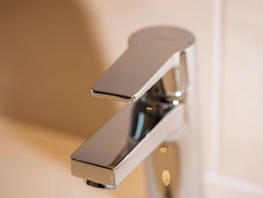 A modern, chrome faucet with a single handle and a pull-down spray head. - Atlantis Apartments by MEIN SAMNAUN – MOUNTAIN HOMES, (Samnaun-Ravaisch) by Interhome (Samnaun-Ravaisch)