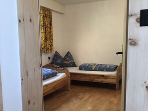 A small room with two wooden bunk beds, each with blue bedding and decorative pillows. - Chasa Beliur, (Scuol) by Interhome (Scuol)