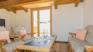 Ein Holzinnenraum mit Tisch, Stühlen und einer Couch.