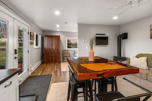 Una cocina moderna con una mesa de madera, taburetes de bar y una estufa empotrada.